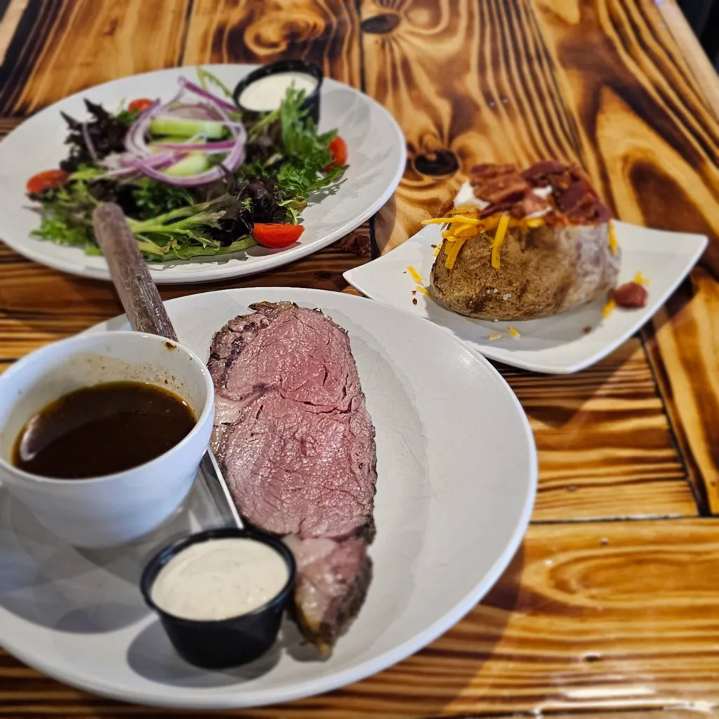 Seared prime rib plated with roasted vegetables at Skillet Southern Bistro